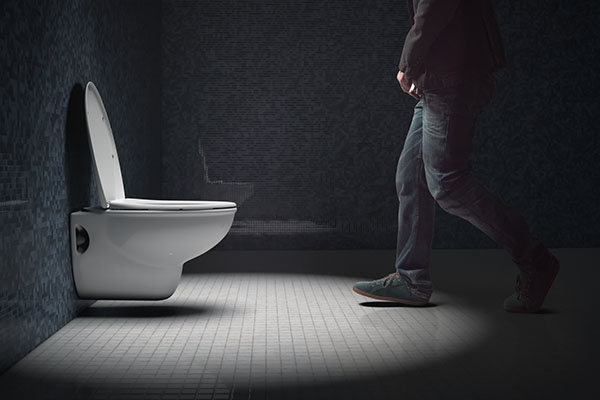 A man rushing to the toilet. Side view. Topics of health, digestion and hygiene